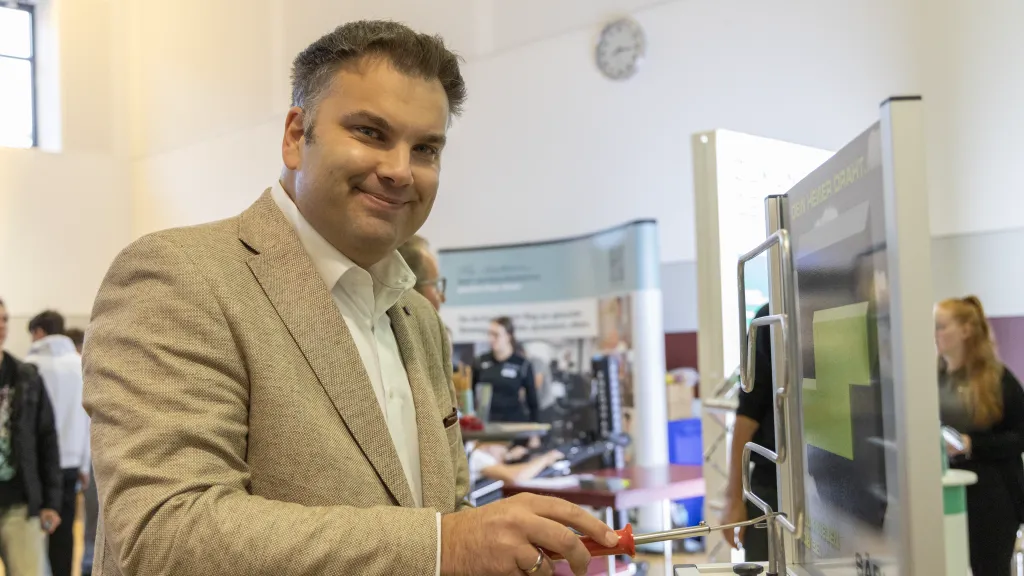 Bürgermeister Jan Schuhmacher aus Morsbach auf der Ausbildungsmesse von der Leonardo da Vinci Schule, steht am Messe Stand von SÄBU und versucht sein Glück am Heißen Draht.